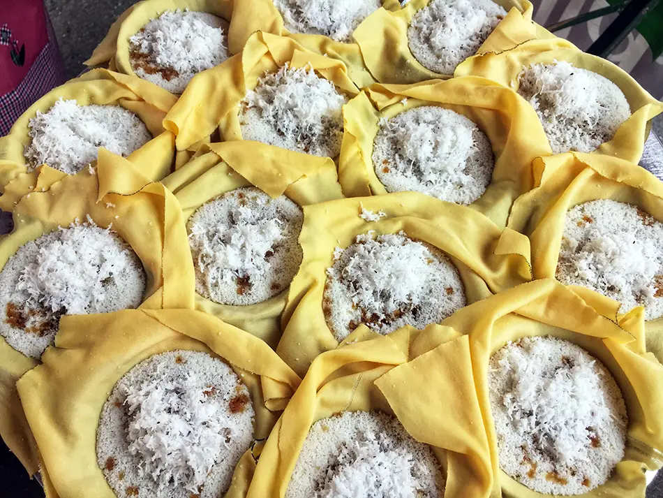 Steamed putu piring rice cakes with gula melaka filling and grated coconut.