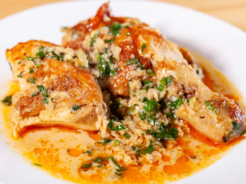 Traditional Georgia dishes: shkmeruli chicken with garlic cream sauce, crispy skin, plated.