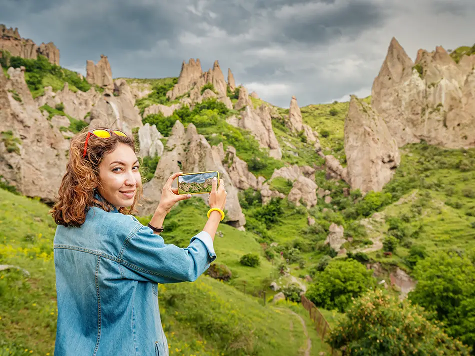 Traveler photographing Old Goris cliffs after rain.