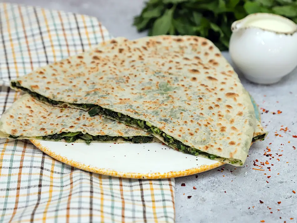 Zhingyalov hats herb flatbread on a plate, a staple of Local Food.