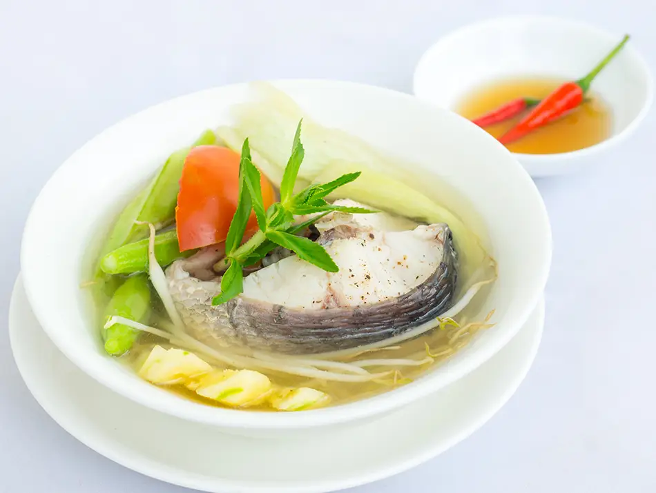 Sour tamarind broth with pineapple, tomato and catfish — one of the national dishes of Vietnam.
