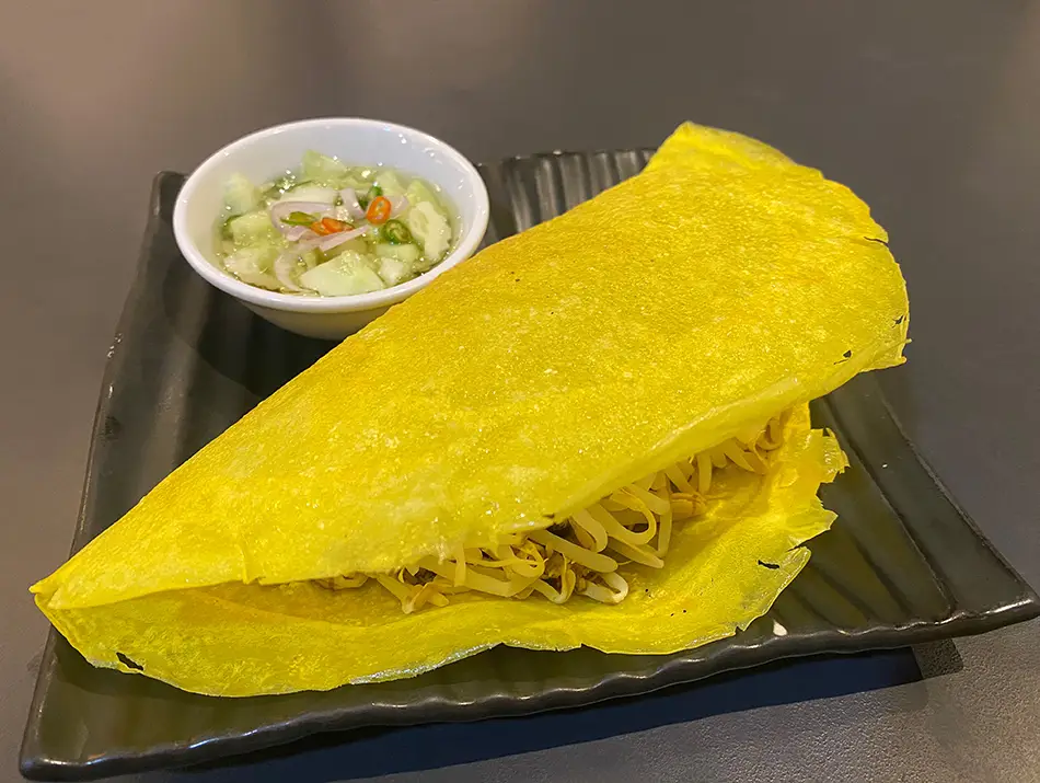 olden bánh xèo pancake folded with shrimp and bean sprouts.