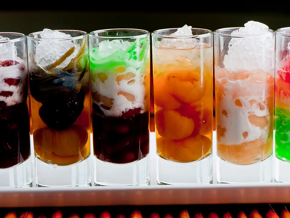Glass of chè ba màu with layers of beans, jelly and coconut milk, a must-try sweet in Vietnam.