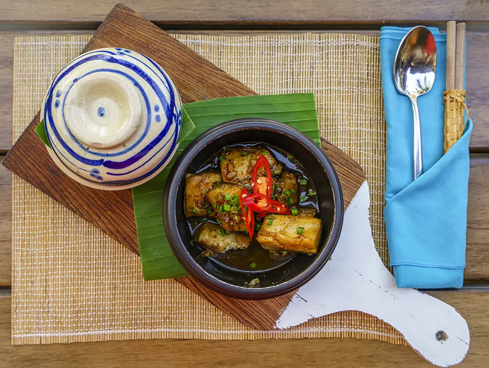Caramelized catfish simmered in a clay pot with scallions and chili peppers.
