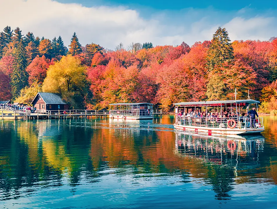 Turquoise cascades at Plitvice Lakes surrounded by blazing Fall Colors in Europe.