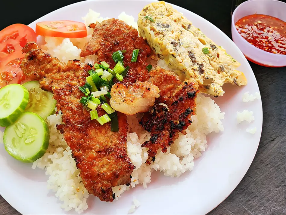 Broken rice served with grilled pork chop, egg meatloaf and shredded pork skin.