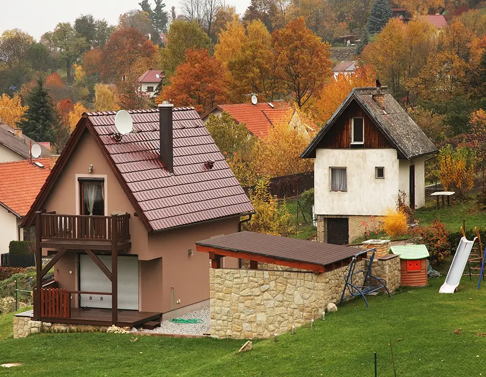 Cozy hillside cottages with steep roofs surrounded by orchards and warm evening light.