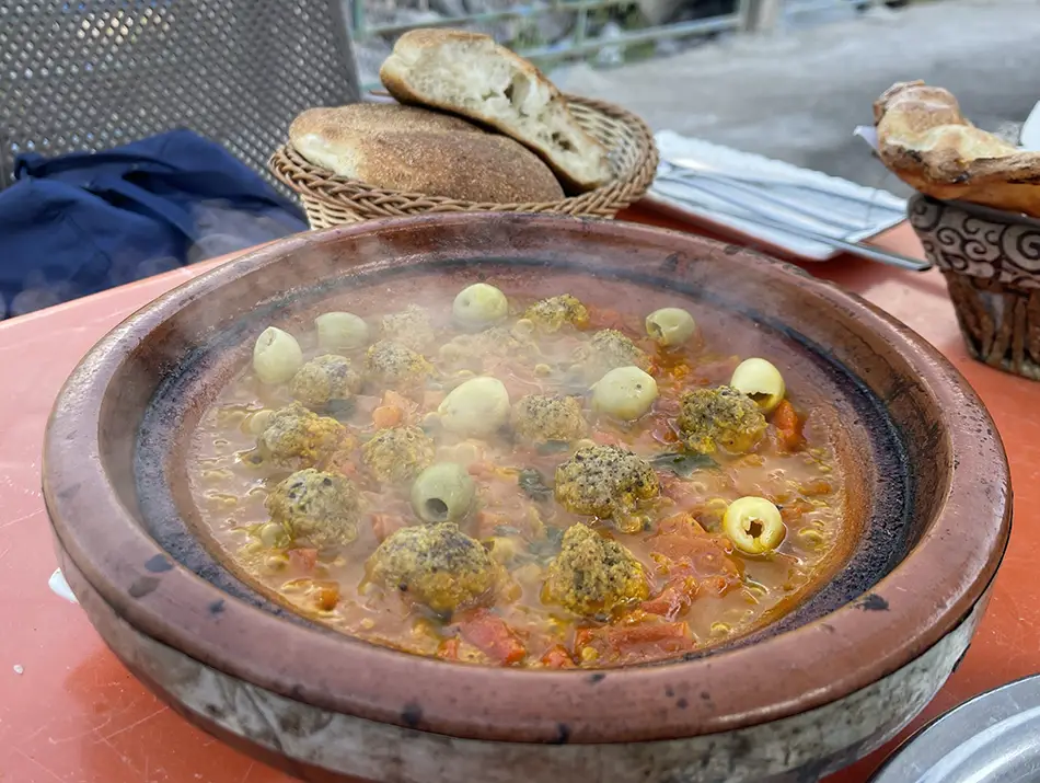 Bubbling vegetable tagine, showcasing local food in Imlil, served in clay.