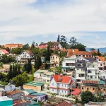Panoramic aerial view showing hillside homes, pine trees, and distant mountains highlighting the best