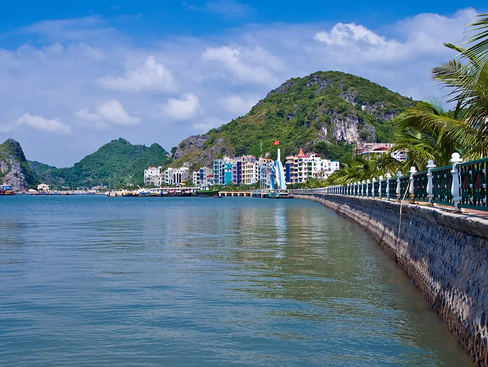 Seaside promenade with calm waters and hills