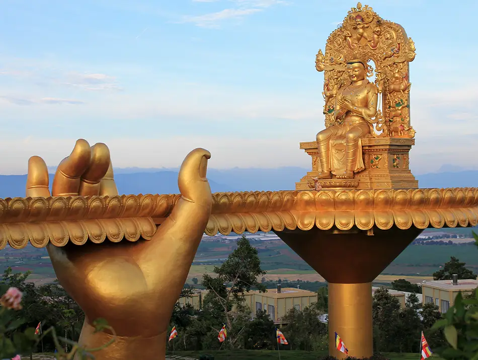 Giant golden Buddha statue resting on an enormous sculpted hand at Samten Hills Monastery. A peaceful daytrip from Dalat