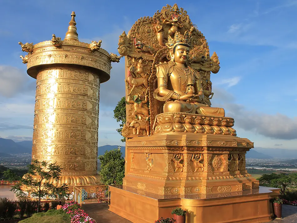 Golden Buddha statue and giant prayer wheel at Samten Hills