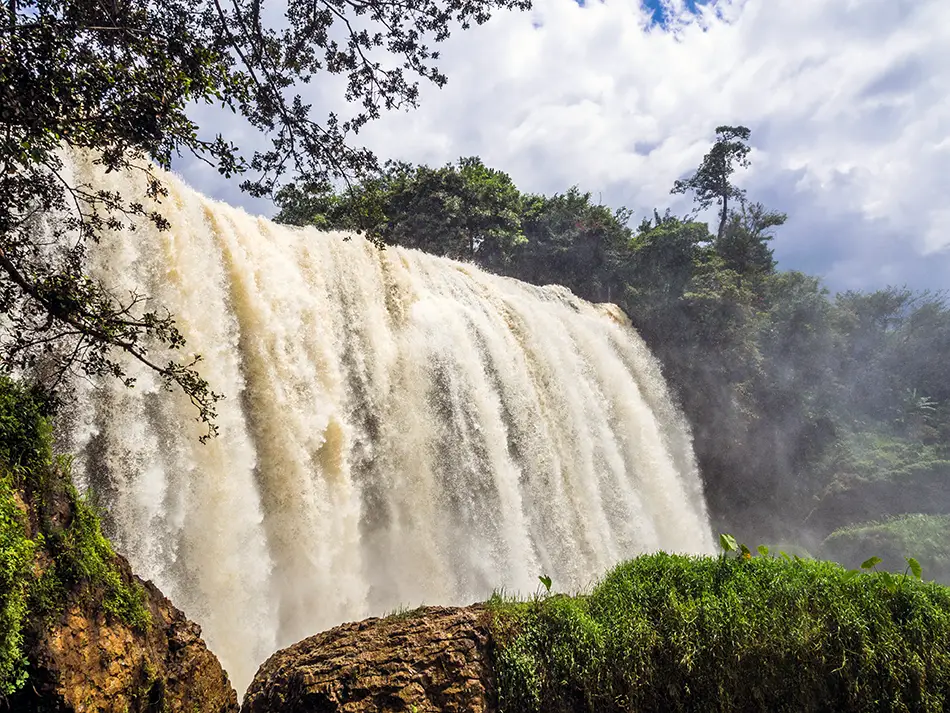 Water plunging over dark basalt cliffs at Elephant Waterfall, a must-see natural attraction in Dalat.