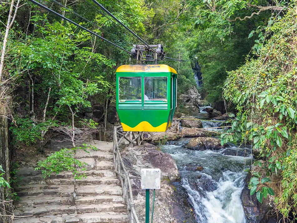 A cable car riding next to Datanla waterfall stream - fun thing to do in Dalat