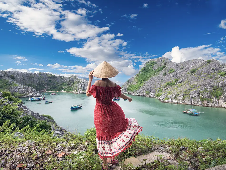 Local-style dress worn by a visitor at a Cat Ba lookout, linked to practical tips for Cat Ba Island.