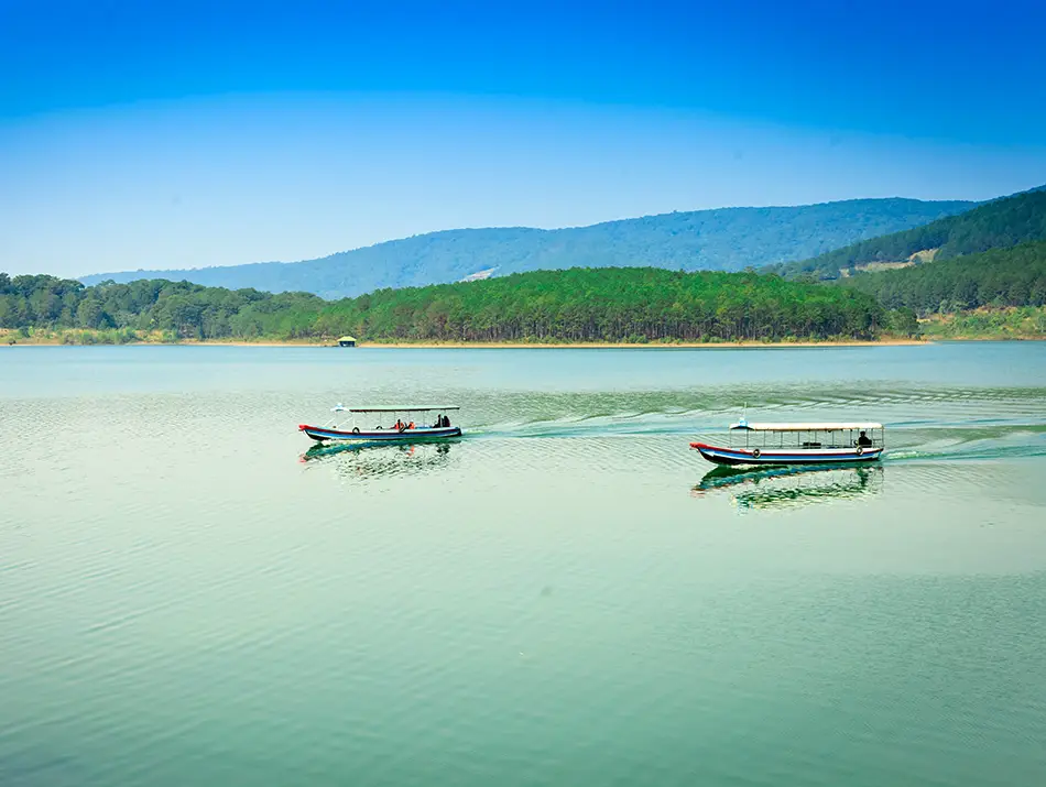 Wooden boats resting on calm water at Tuyen Lam Lake, one of the best places to visit in Dalat.