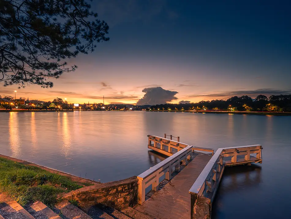 Night view of the lake with reflections of city lights, offering a peaceful glimpse into nightlife in Dalat.
