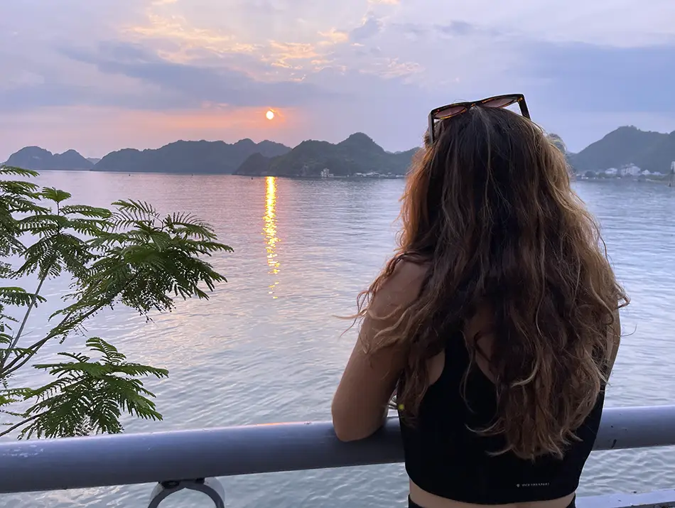 Traveler watching sunset over limestone islands, one of the best things to do in Cat Ba Vietnam.
