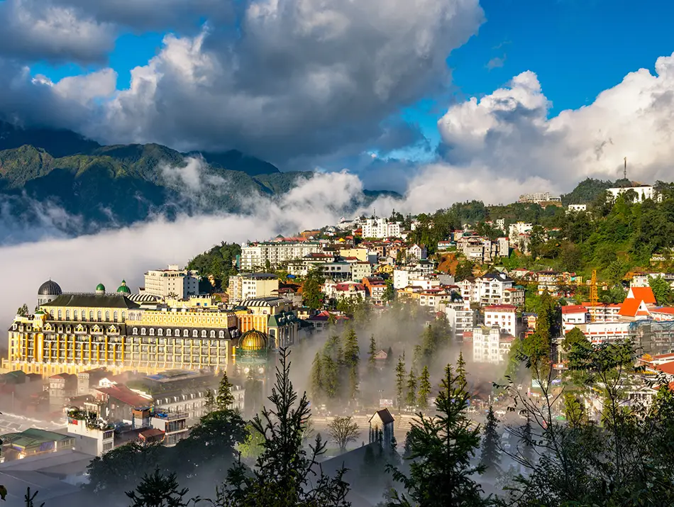 Sunlight breaks over Sapa’s lakefront hotels and mountain backdrop