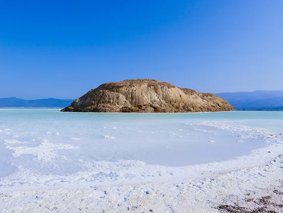Brilliant white salt shore and clear blue water creating a dream travel destination.