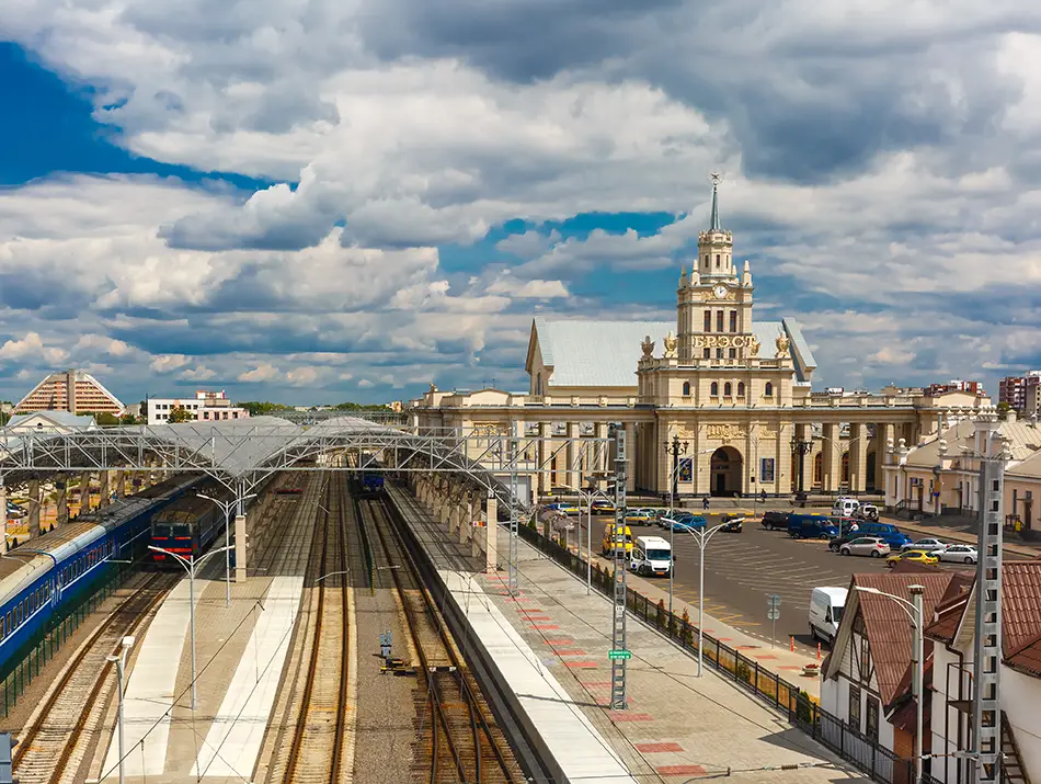 Large rail terminal with platforms leading toward a classical station building.