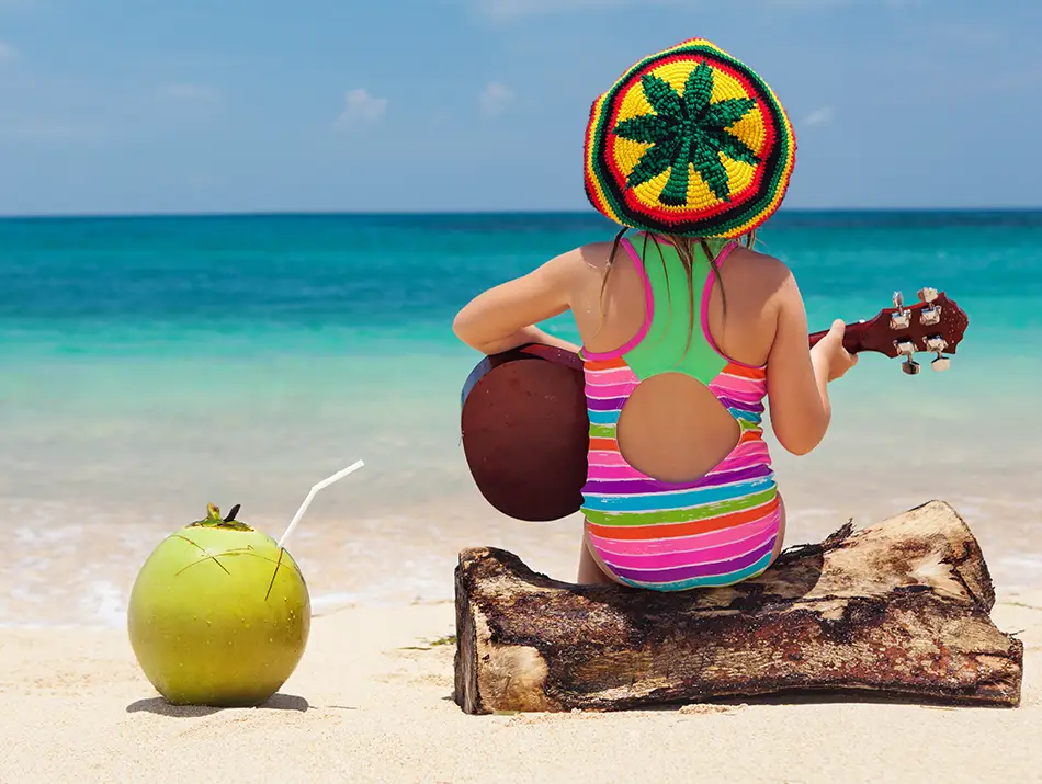 Traveler relaxing on a quiet beach with guitar and fresh coconut in one of the best countries to visit.