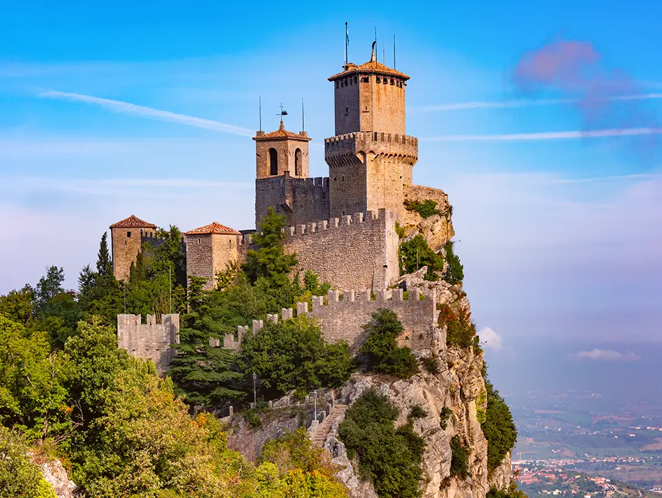 Stone fortress perched high on a rocky ridge under a wide open sky.