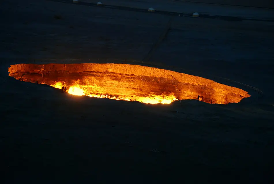 Flaming pit glowing in the dark desert landscape.