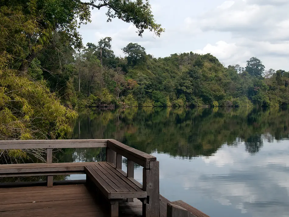 Wooden jetty extending over calm reflective lake waters.