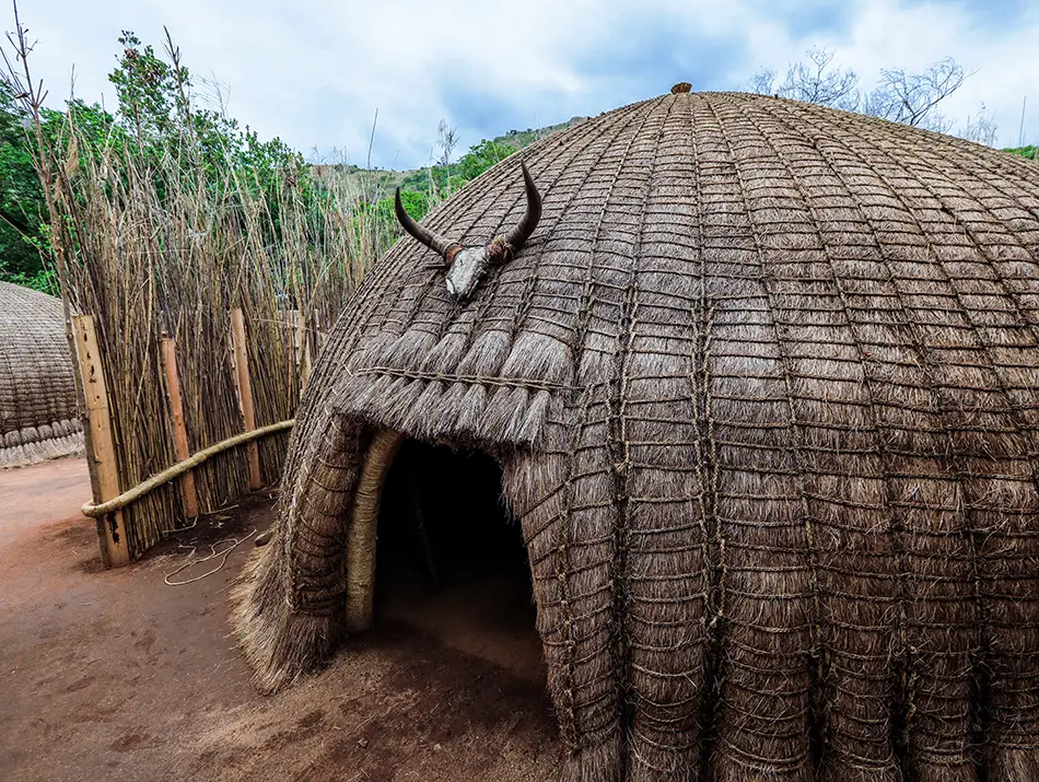 Woven dome-shaped traditional hut in a rural village, a sustainable tourism destination.