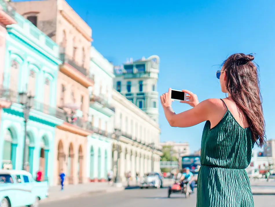 Traveler photographing colorful facades in Havana, showcasing one of the best countries to visit in 2026.