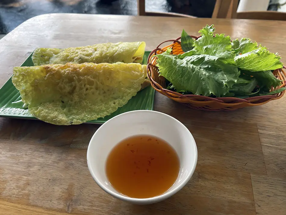 Freshly made vegetarian Banh Xeo pancake, showing how clean and safe Vietnamese street food can look.