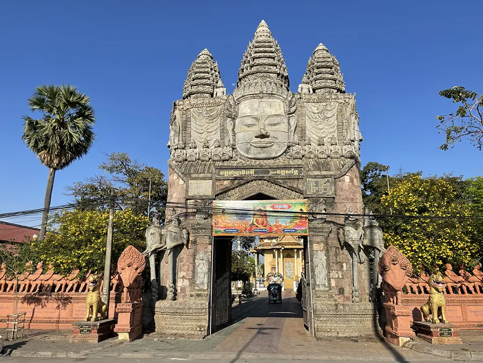 Decorated gateway frames the grounds of a colorful pagoda in Battambang.