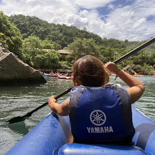 A kayaker paddles the calm river leading to Dark Cave, offering one of the Best Things to Do in Phong Nha