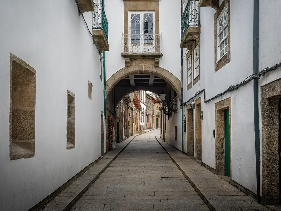 A cobblestone alley in historic Guimarães, Portugal, a charming stop for cultural travel.