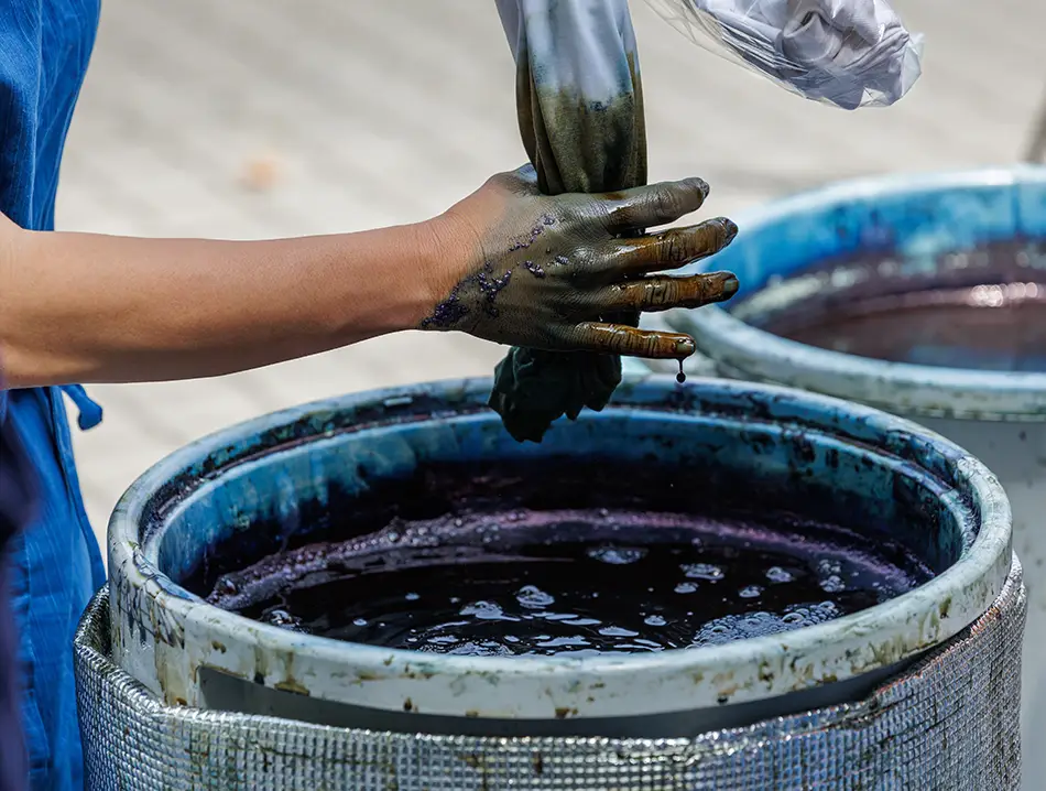 Watching artisan dip fabric in indigo vat, among the best things to do in Sapa.