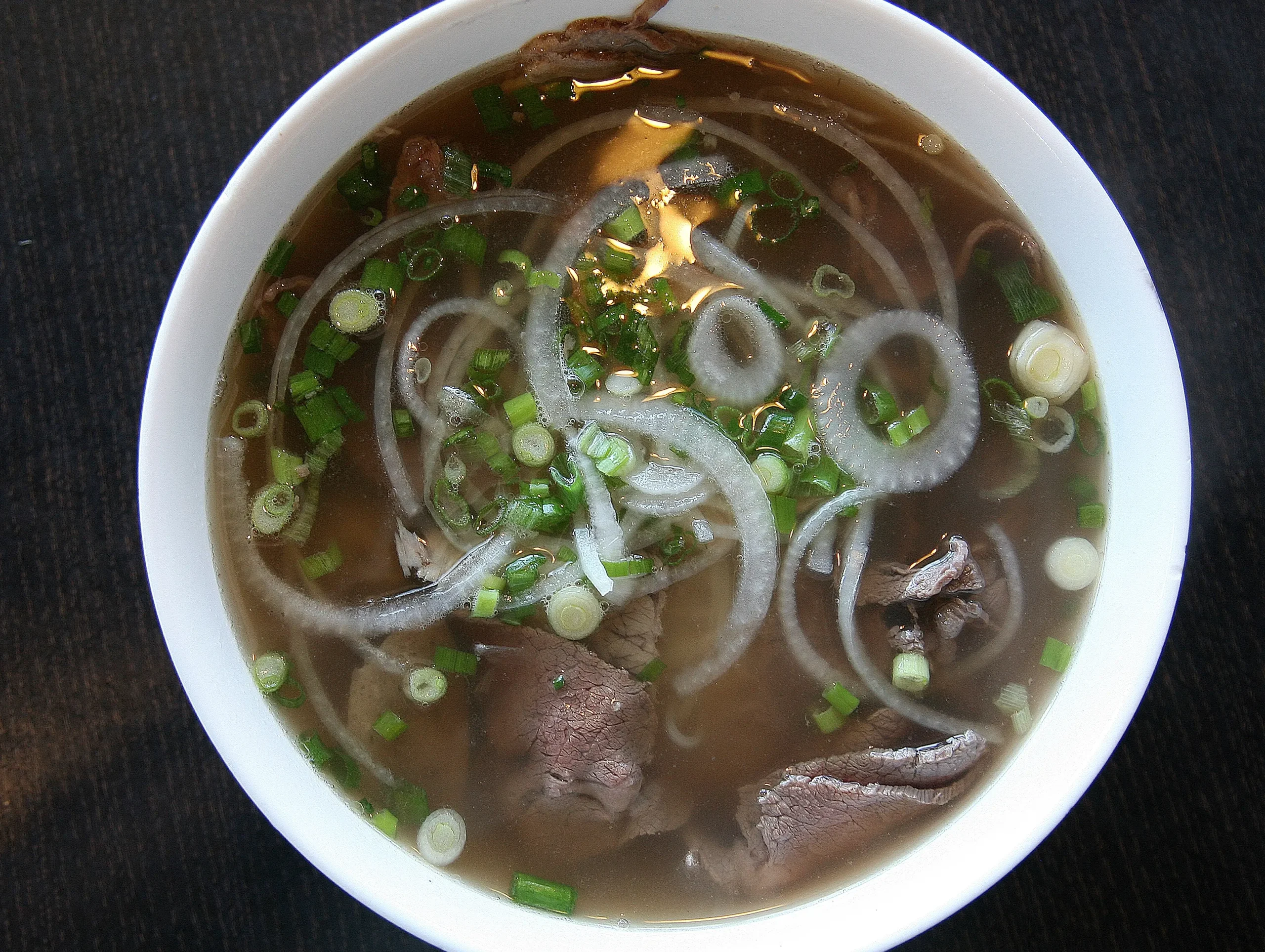 Bowl of Pho Bo beef noodle soup, a famous Hanoi street food enjoyed across Vietnam.