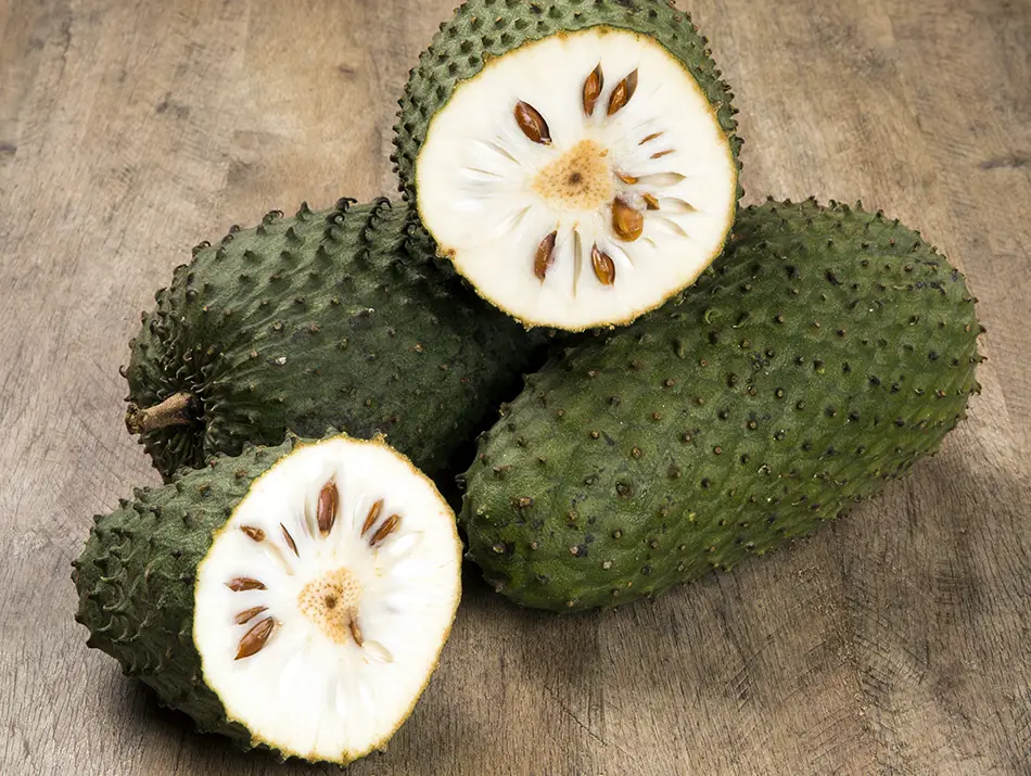 Fresh soursop with its spiky green skin and creamy white flesh, often seen as a strange fruit in Vietnam for first-time visitors.
