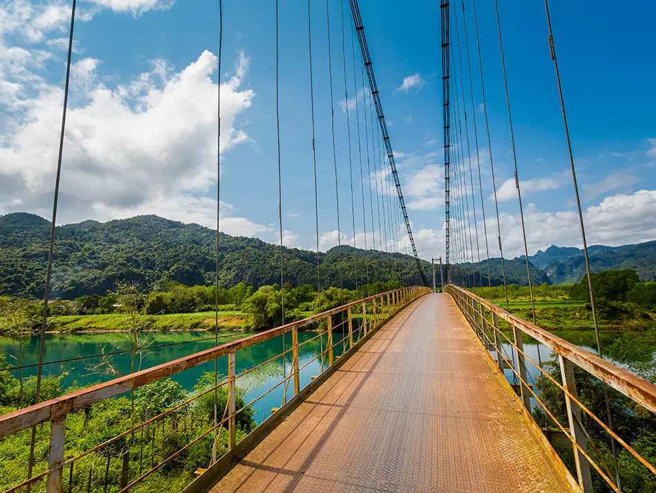 A long suspension bridge stretches across the river