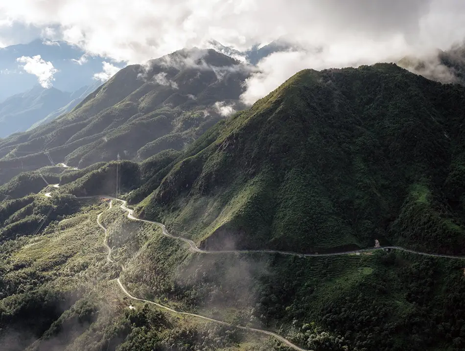 Morning mist drifts between steep ridges along Tram Ton Pass, one of the highest routes in northern Vietnam.