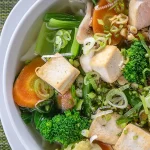 A bright bowl of tofu, noodles and vegetables showcasing vegetarian food in Vietnam.