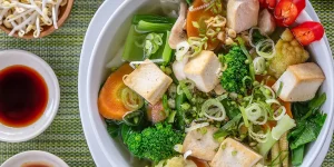 A bright bowl of tofu, noodles and vegetables showcasing vegetarian food in Vietnam.