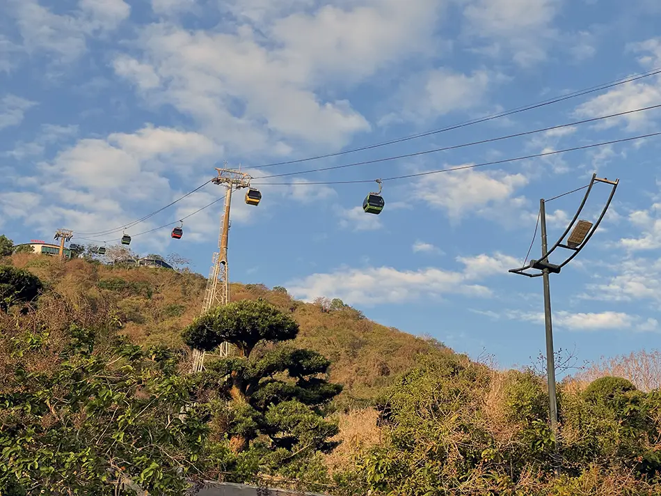 Cable car gliding above forested hills, one of the popular activities in Vung Tau.