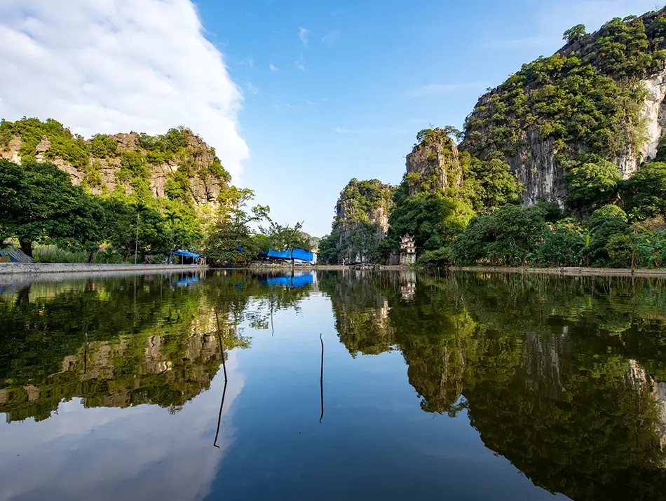 Quiet forest lake reflecting dense tropical trees inside national park.