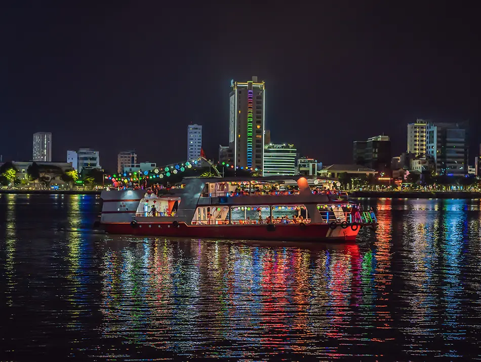 A brightly lit boat cruising along the Han River at night.