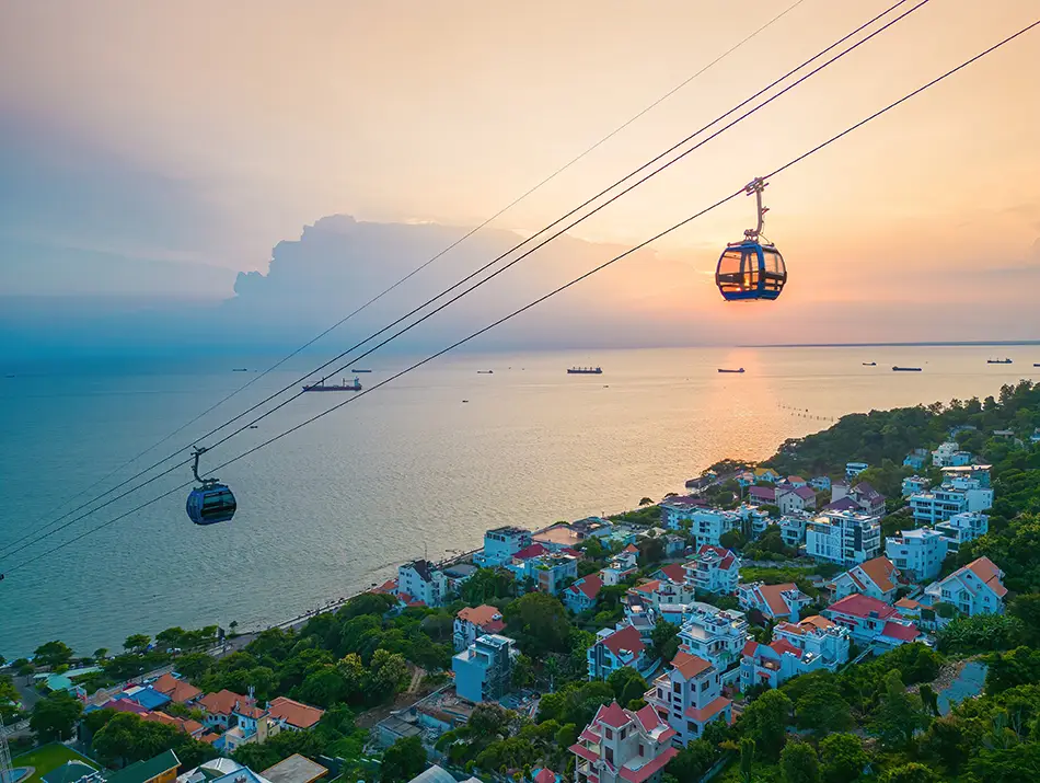 Ho May Park cable car cabins moving across the sky during sunset, with warm colors lighting the scene.