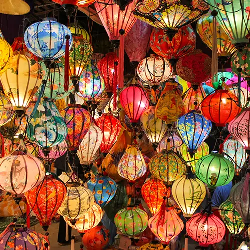 Colorful silk lanterns hanging closely together inside a Hoi An shop.
