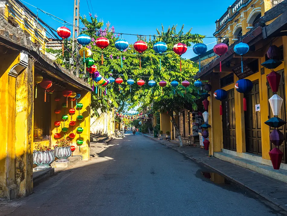 Colorful lanterns hang above a quiet heritage street showcasing best things to do in Hoi An.
