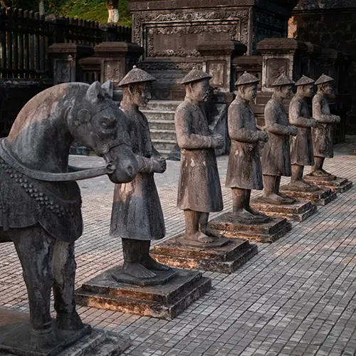 A row of stone guardian statues standing in formation at a royal tomb complex.
