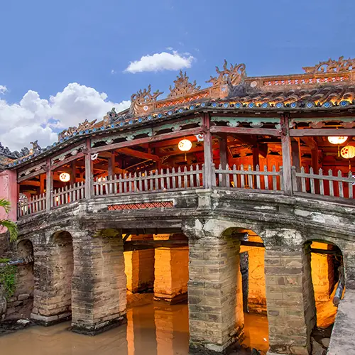 The historic Japanese Covered Bridge reflecting in the canal at dusk, a classic highlight on day trips from Da Nang.
